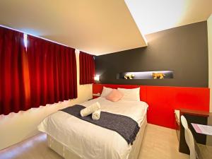 1 dormitorio con 1 cama grande y paredes rojas en 寵愛逢甲 en Taichung