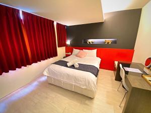 een slaapkamer met een bed met rode gordijnen en een bureau bij 寵愛逢甲 in Taichung