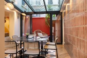 a dining room with a table and chairs and a laptop at Hotel Elysees 8 in Paris