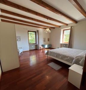 una camera con letto e pavimento in legno di Corte San Lorenzo a Desenzano del Garda