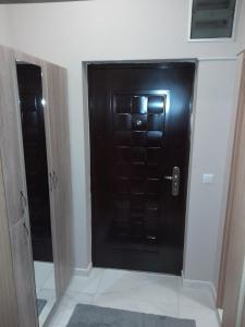 Una puerta negra en una habitación con puerta en Gray Apartament 2 Pristina en Pristina