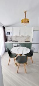 eine weiße Küche mit einem Tisch und 2 Stühlen in der Unterkunft Villacana 2106 in Estepona