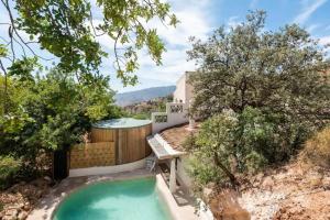 een achtertuin met een zwembad, een hot tub en bomen bij Apartamento Caolin Rocabella in El Chorro