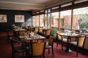 a dining room with tables and chairs and windows at Downhill Inn in Ballina