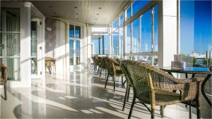 فندق ذا كمبرلاند في إيستبورن: صف من الكراسي والطاولات على مبنى به نوافذ