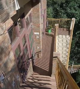 un conjunto de escaleras de madera que conducen a una casa en Anuppam Home Stay, en Kulu