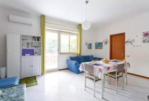 un soggiorno con un tavolo e un divano blu di Nest Apollo a Mondello