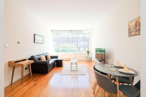 sala de estar con sofá negro y mesa en Lovely 2 bed flat in canal side gated development, en Londres