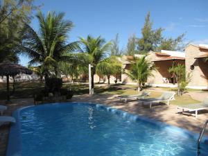 a swimming pool in a yard with palm trees at Pousada 7 Mares in Canoa Quebrada