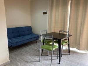 a room with a table and chairs and a couch at Departamentos Lipangue in Algarrobo