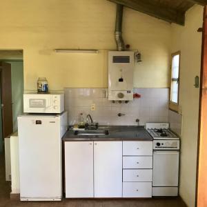 a kitchen with white appliances and a sink at Los Zarzos in Mina Clavero