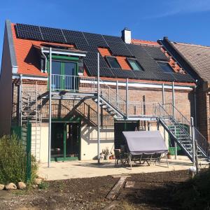 una casa con paneles solares en el techo en Ferienwohnung in historischem 3-Seitenhof en Leipzig