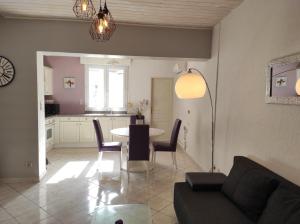 un soggiorno con tavolo e sedie e una cucina di Au sable fin a Grand-Fort-Philippe