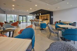 une salle à manger avec des tables, des chaises et une table dans l'établissement DOMITYS Le Piano Résidence Sénior, à Lille