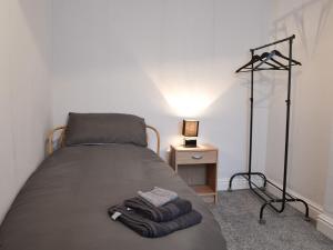 a bedroom with a bed with two towels on it at Quarry Cottage in Bethesda