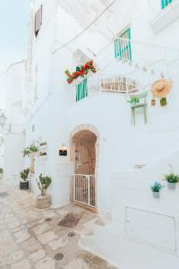 une maison blanche avec des murs blancs et un escalier dans l'établissement Grotta Carlotta, à Ostuni