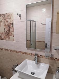 a bathroom with a sink and a mirror at Comfortable Ground Floor Studio in Primorsko