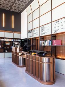 una biblioteca con una fila de escritorios y libros en JOST Hôtel Bordeaux Centre Gare Saint Jean en Burdeos