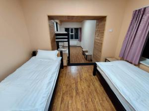 two beds in a small room with a hallway at Kharkhorin hostel in Harhorin