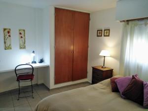 1 dormitorio con 1 cama, 1 silla y 1 armario en Depto En El Centro - Dean Funes en Córdoba