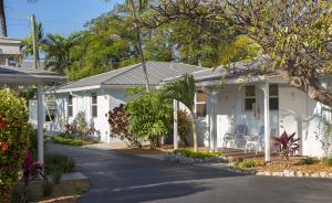 a white house with a porch and chairs on a street at Southwinds Motel in Key West