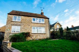 une maison en briques avec des fenêtres blanches sur une cour verdoyante dans l'établissement Stay in Westow, à Westow