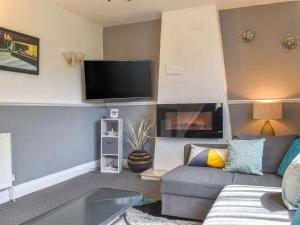 a living room with a couch and a fireplace at Huddersfield House, Wood View in Huddersfield