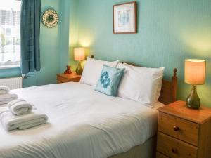 a bedroom with a large white bed with blue walls at Jennys in Stalham