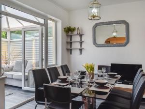a dining room with a table and chairs and a mirror at Huddersfield House, Wood View in Huddersfield