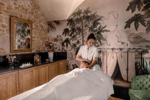 a woman cutting a mans hair in a salon at Relais Christine in Paris