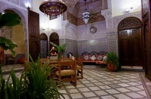 sala de estar con mesa y sofá en Riad Fes Palacete, en Fez