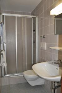 ein Bad mit einer Dusche, einem WC und einem Waschbecken in der Unterkunft Gästehaus Pension Edelweiss in Kolsass