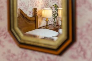 a mirror reflection of a bed in a room at Hotel des Grandes Ecoles in Paris