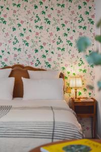 a bedroom with a bed with a floral wallpaper at Hotel des Grandes Ecoles in Paris