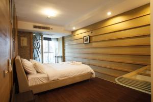 a bed in a room with a wooden wall at 2bedrooms3baths Bkk Downtown Near Asoke Btsmrt in Makkasan