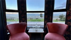 two chairs and a table in front of a window at Avoca Hotel in Newcastle