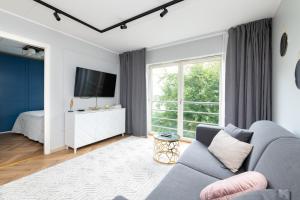 un soggiorno con divano e TV di Central Rosi Art Deco Apartment with parking a Tallinn