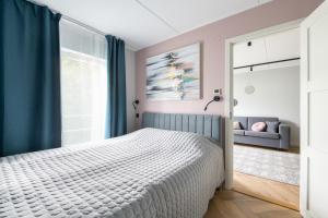 una camera con letto bianco e tende blu di Central Rosi Art Deco Apartment with parking a Tallinn