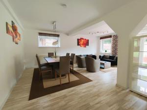 a dining room and living room with a table and chairs at Ferienwohnungen MAXIMA in Bad Arolsen