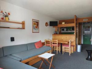 ein Wohnzimmer mit einem blauen Sofa und einem Tisch in der Unterkunft Appartement Les Arcs 1800, 2 pièces, 5 personnes - FR-1-411-98 in Arc 1800