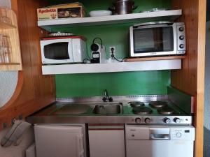 eine kleine Küche mit einer Spüle und einer Mikrowelle in der Unterkunft Appartement Les Arcs 1800, 2 pièces, 5 personnes - FR-1-411-98 in Arc 1800