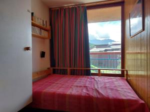 ein Schlafzimmer mit einem Bett und einem großen Fenster in der Unterkunft Appartement Les Arcs 1800, 2 pièces, 5 personnes - FR-1-411-98 in Arc 1800