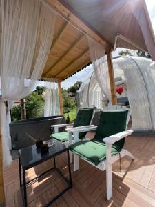 a patio with green chairs and a table at Cupola glamping dome Sarajevo in Sarajevo