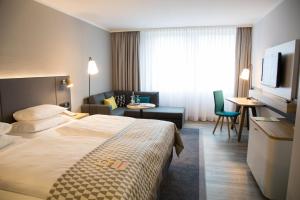 諾伊斯的住宿－Holiday Inn Düsseldorf-Neuss, an IHG Hotel，酒店客房设有床和客厅。