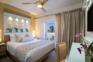 a bedroom with a large bed and a large window at Santa Maria Suites Resort in Key West