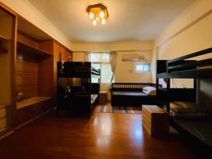 ein Wohnzimmer mit einem Bett und Etagenbetten in der Unterkunft Luye Jamie's Guesthouse in Luye