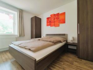 um quarto com uma cama com duas pinturas na parede em Ferienwohnungen MAXIMA em Bad Arolsen