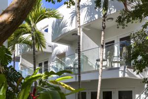 a white house with palm trees in front of it at Santa Maria Suites Resort in Key West