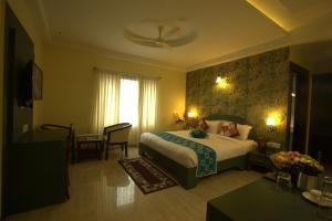 a hotel room with a bed and a window at Royal shades kodihali in Bangalore