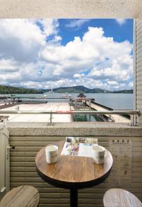 魚池鄉的住宿－湖悅景觀旅店，阳台的桌子,享有水体的景色